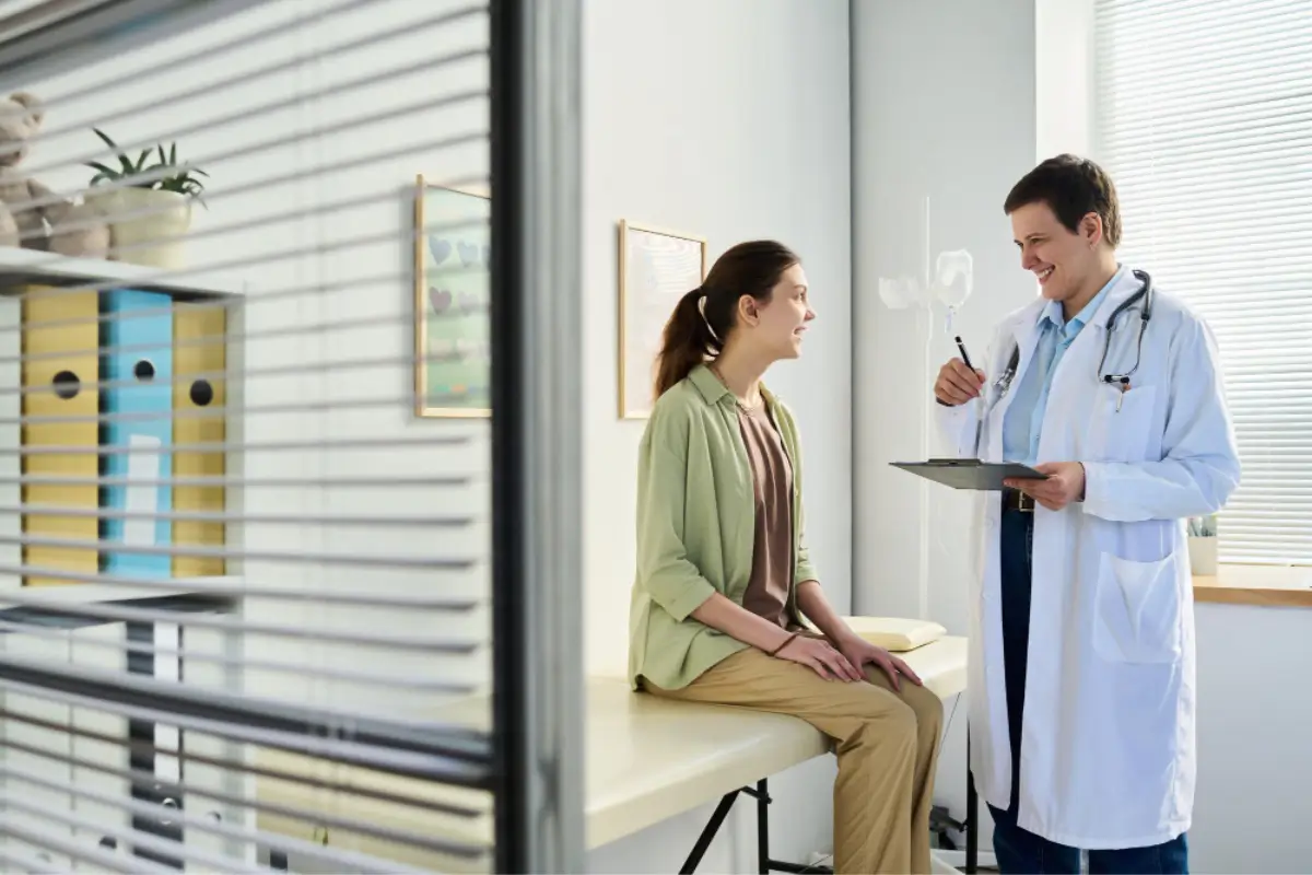 Doctor discussing with a young female patient in clinic, illustrating in-person patient engagement