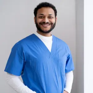 Dr. Luis Rios smiling in blue scrubs, representing approachable medical staff at Human Medical Billing