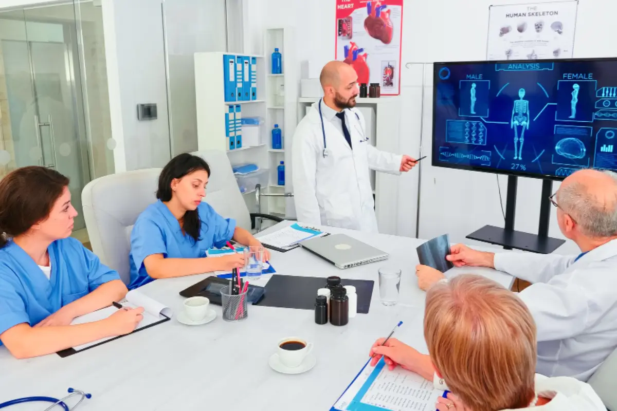 Medical team learning from digital presentation in a hospital, highlighting training at Human Medical Billing
