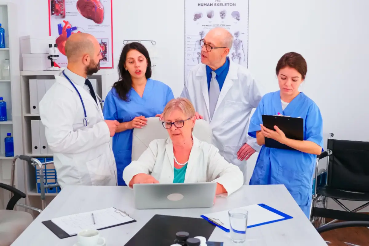 Two doctors in lab coats working on a laptop, showcasing teamwork in medical billing solutions