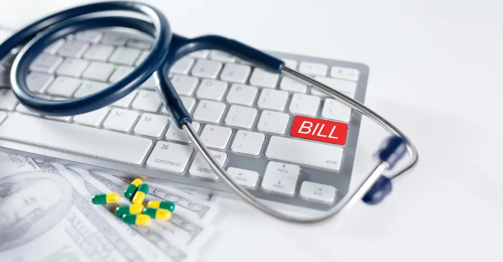 Keyboard with red bill key, stethoscope, and capsules symbolizing the impact of healthcare mergers and acquisitions on medical billing.