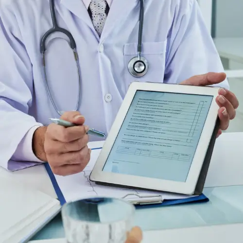 Doctor holding tablet with coding form, symbolizing CPT/ICD accuracy in medical billing.