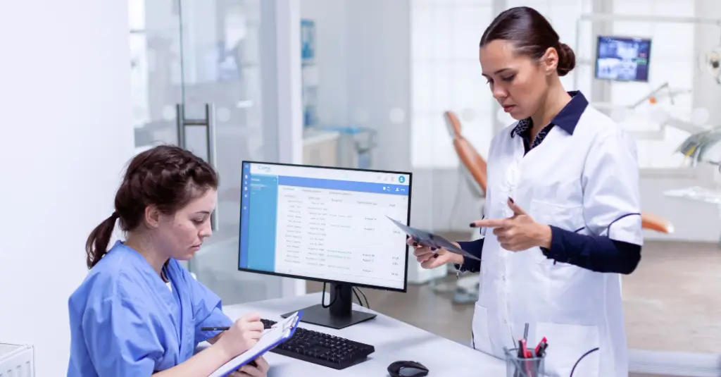 Doctors collaborating on patient documentation for precise HCC coding.
